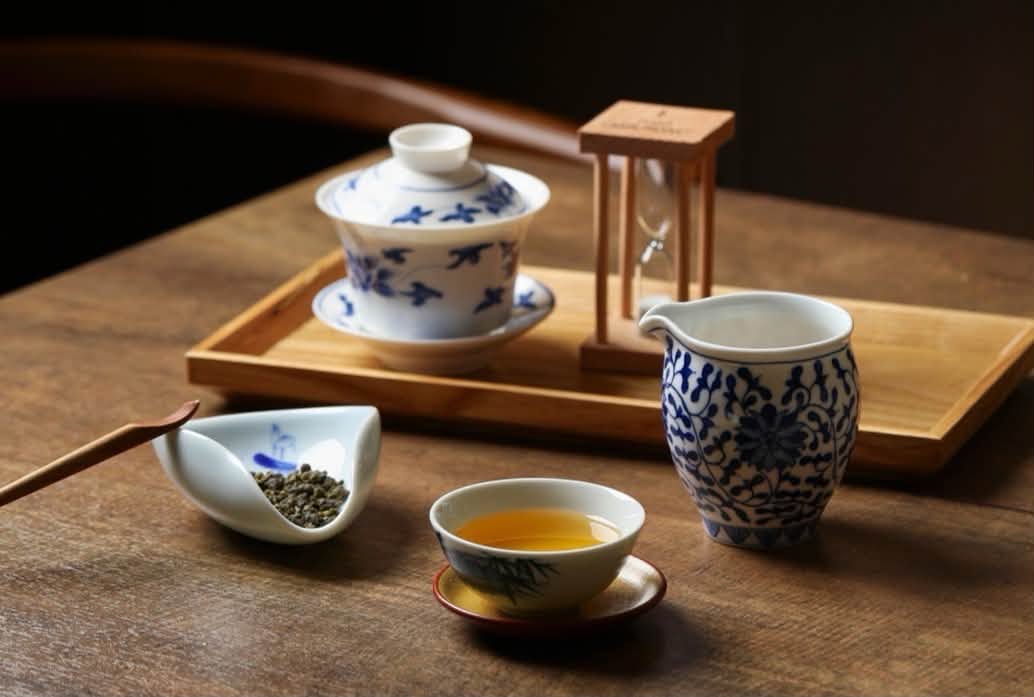 古典茶席中的青花瓷蓋碗、茶海與一杯金黃茶湯